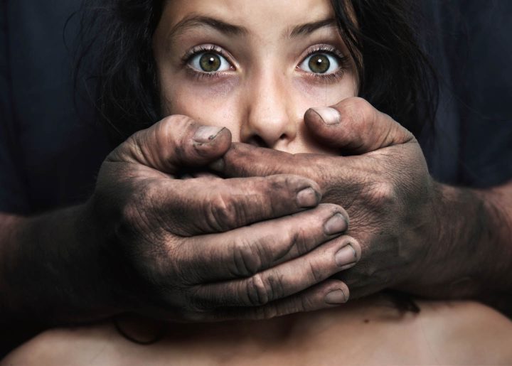 Uma menina sendo abusada pelo pai e com a boca coberta para permanecer em silêncio