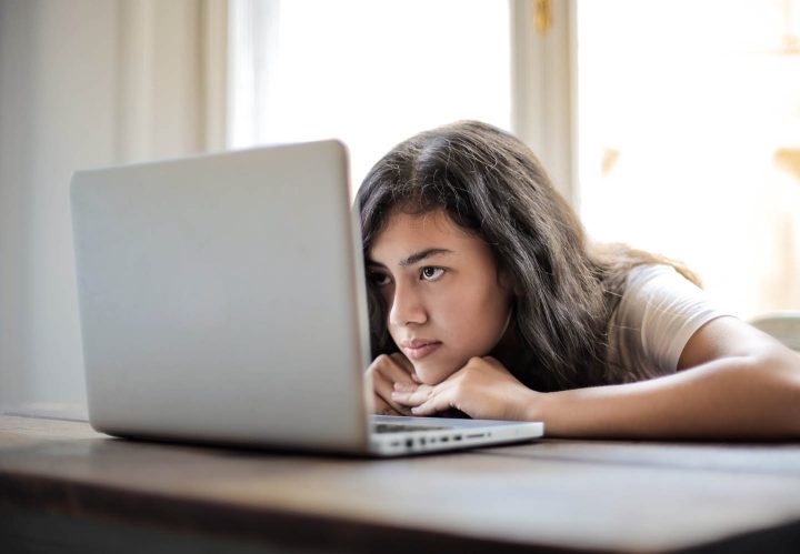 Uma menina em frente do computador, preocupada com a sua aparência nas mídias sociais