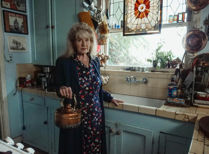 Uma mulher idoso fazendo chá na sua cozinha antiquariada