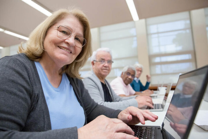 Um grupo de idosos aprendendo a usar um computador