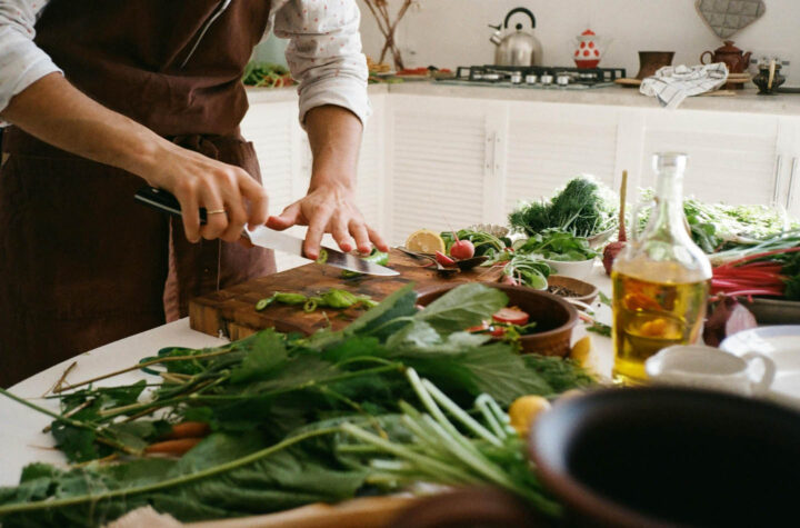 Um homem cozinhando alguns vegetais em casa