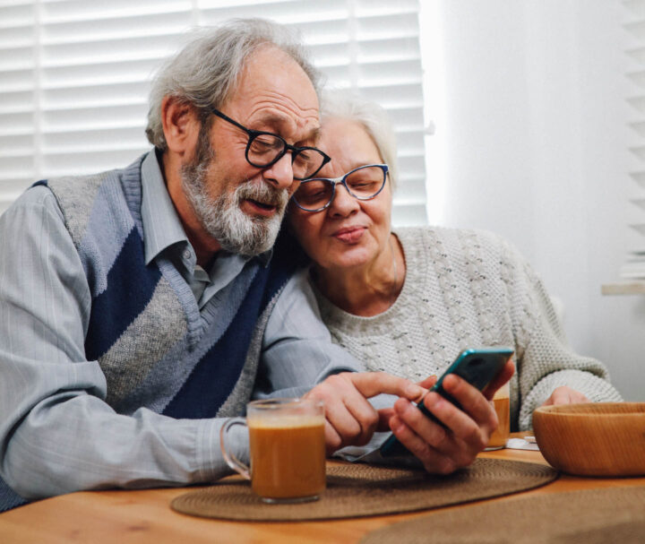 Um casal de idosos assistindo juntos a imagens no celular