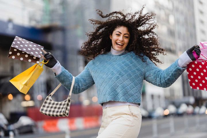 Uma mulher eufórica fazendo compras.