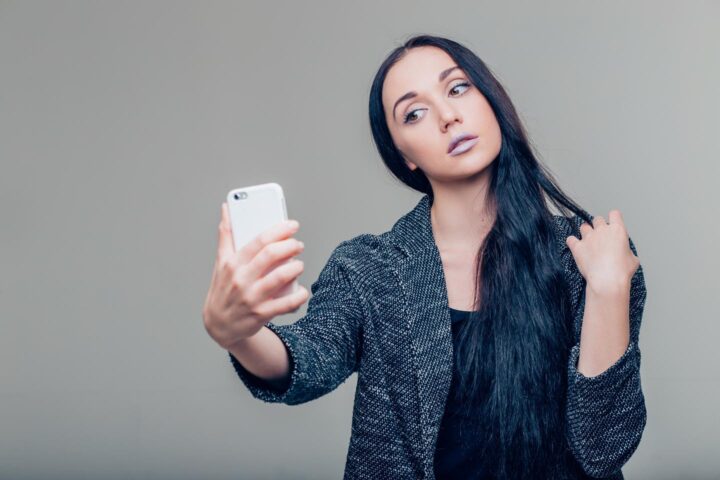 Uma garota preocupada com sua aparência enquanto posa para uma selfie