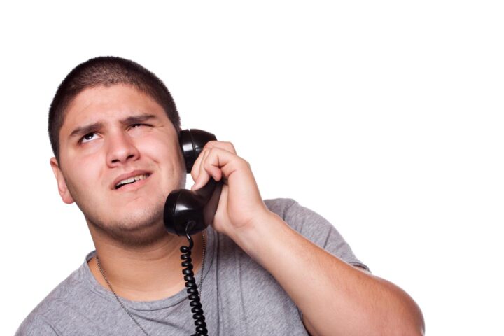 Um homem ouvindo pacientemente uma conversa telefônica irritante