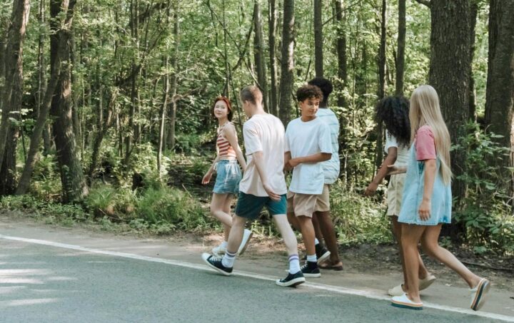 Adolescentes caminhando em uma estrada na floresta