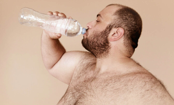 Um homem obeso bebendo água