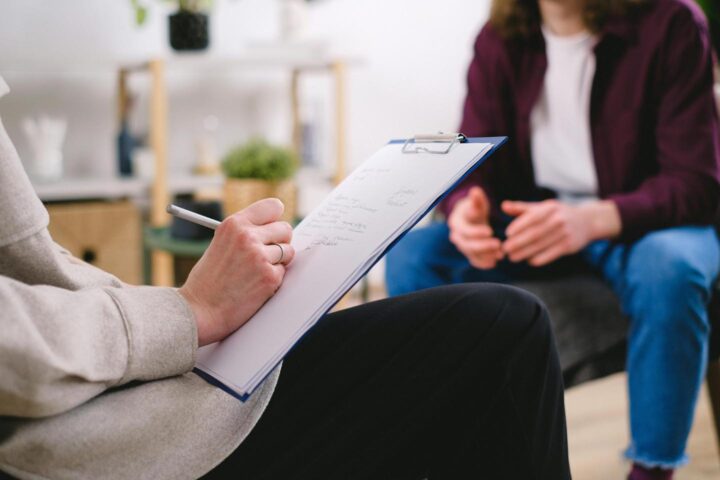 Um psicólogo fazendo anotações em uma consulta