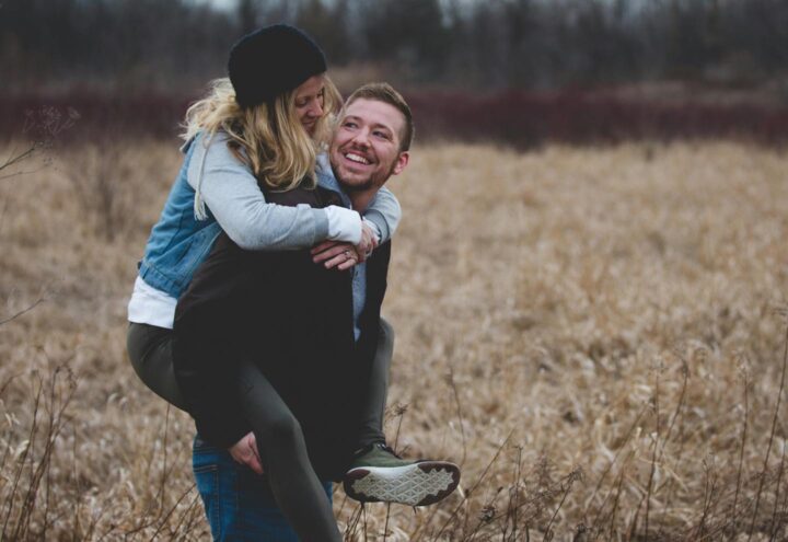 Um homem carregando sua esposa e curtindo a natureza juntos