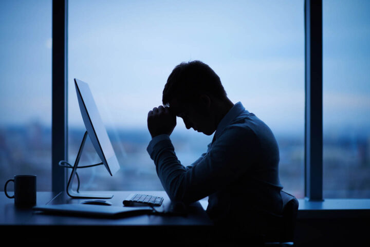 Um homem estressado em frente do computador