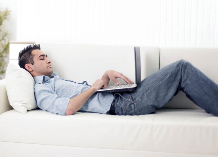 Overstimulated man on couch with computer