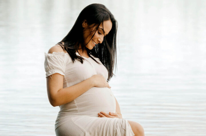 Uma mulher grávida olhando para o seu corpo