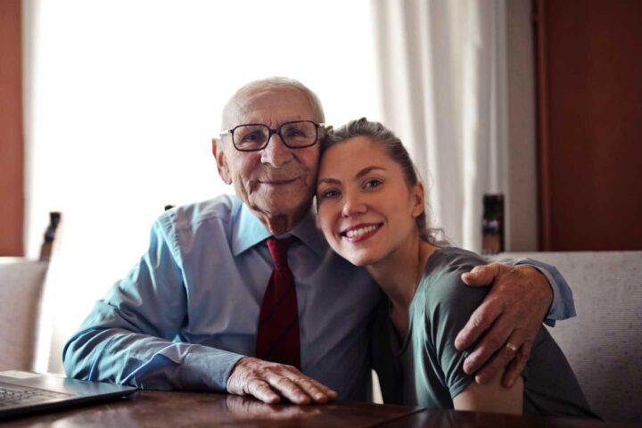 Um senhor idoso recebendo a visita da filha
