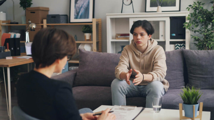 Um adulto conversando com um adolescente